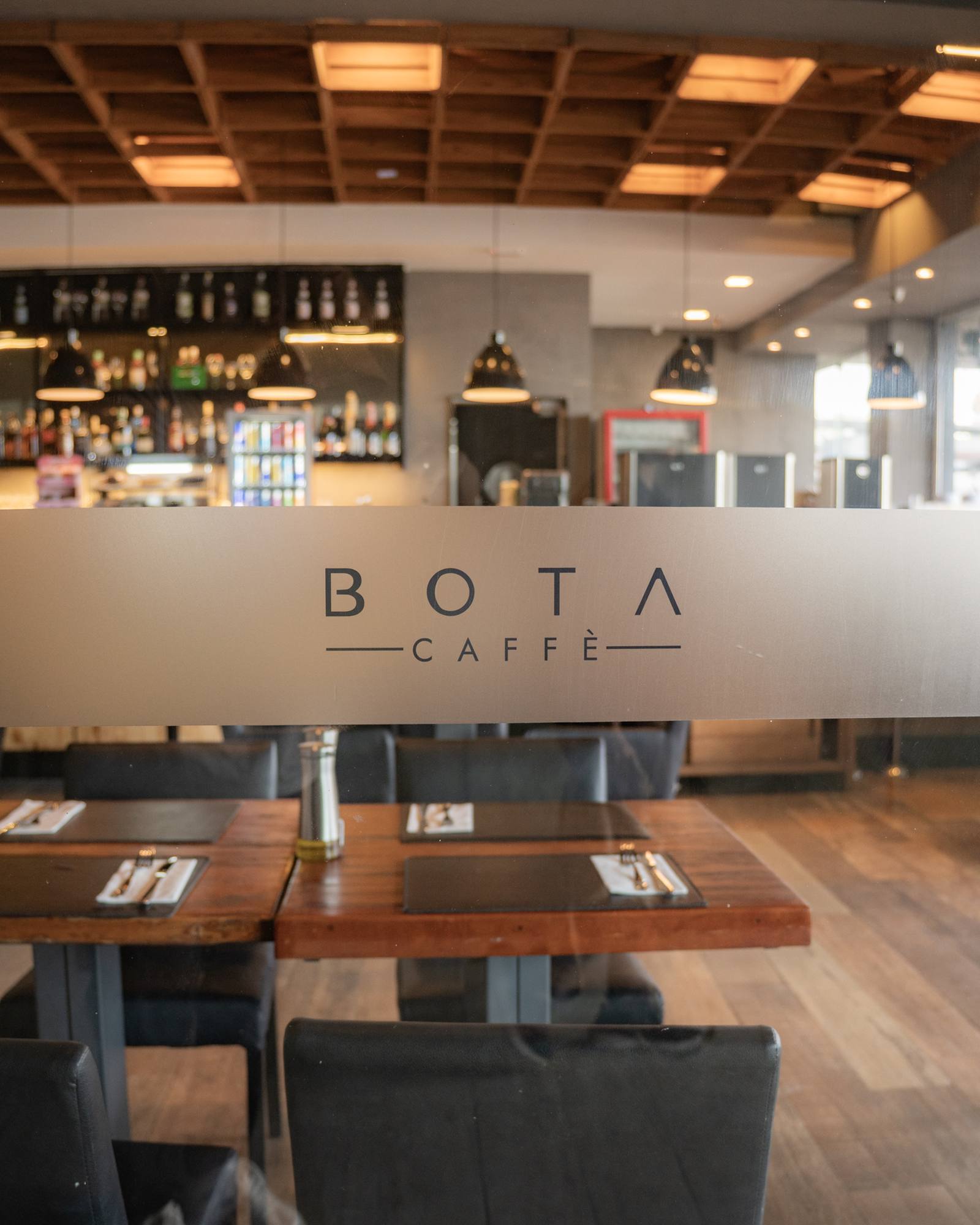 Letreiro BOTA Caffè sobre o balcão